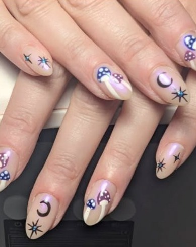 Almond nails painted with tiny mushrooms, crescent moons and stars